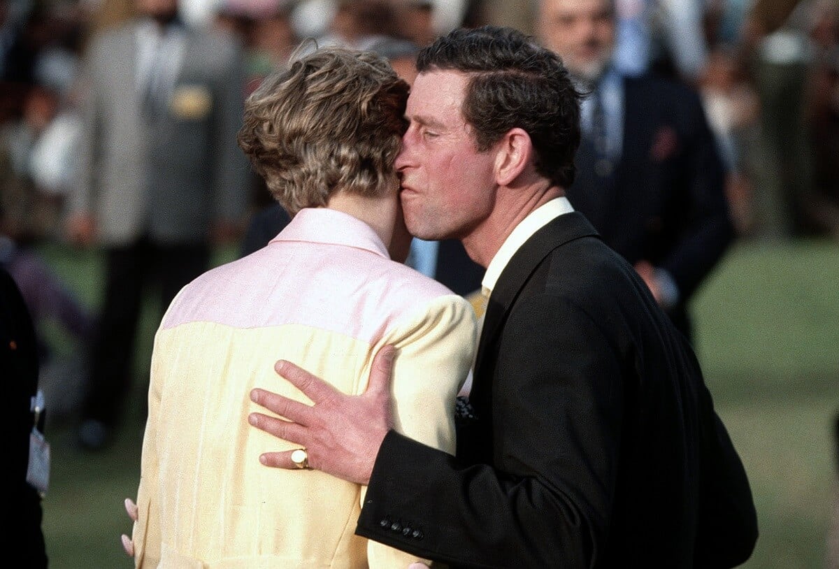 Then-Prince Charles kisses Princess Diana's cheek during a prize giving ceremony at Rajasthan Polo Club