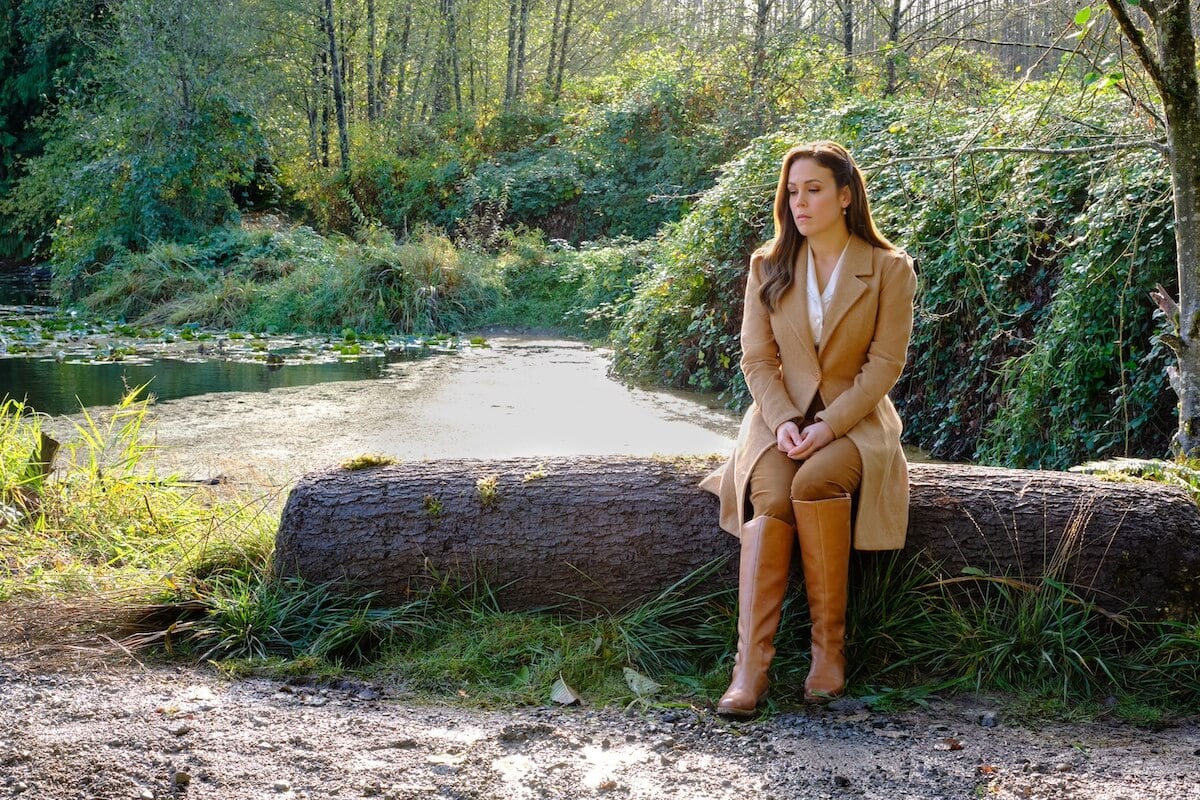 Elizabeth sitting on a log in the 'When Calls the Heart' Season 10 finale