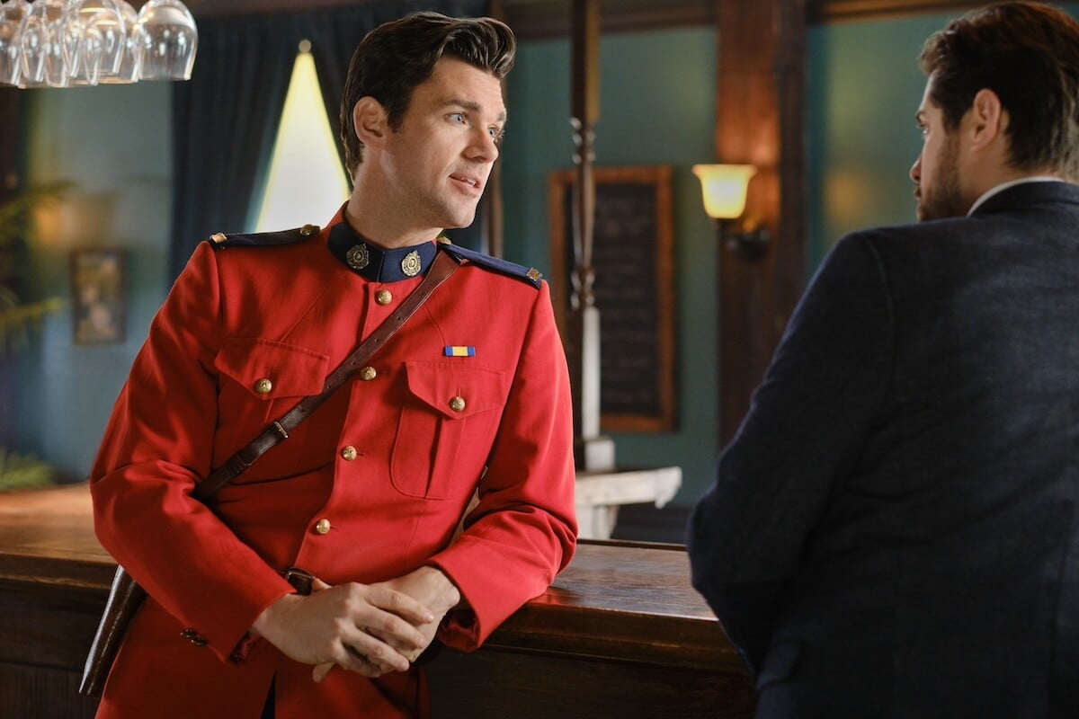 Kevin McGarry as Nathan Grant, in a red coat and leaning on a bar, in 'When Calls the Heart' Season 10 Episode 11