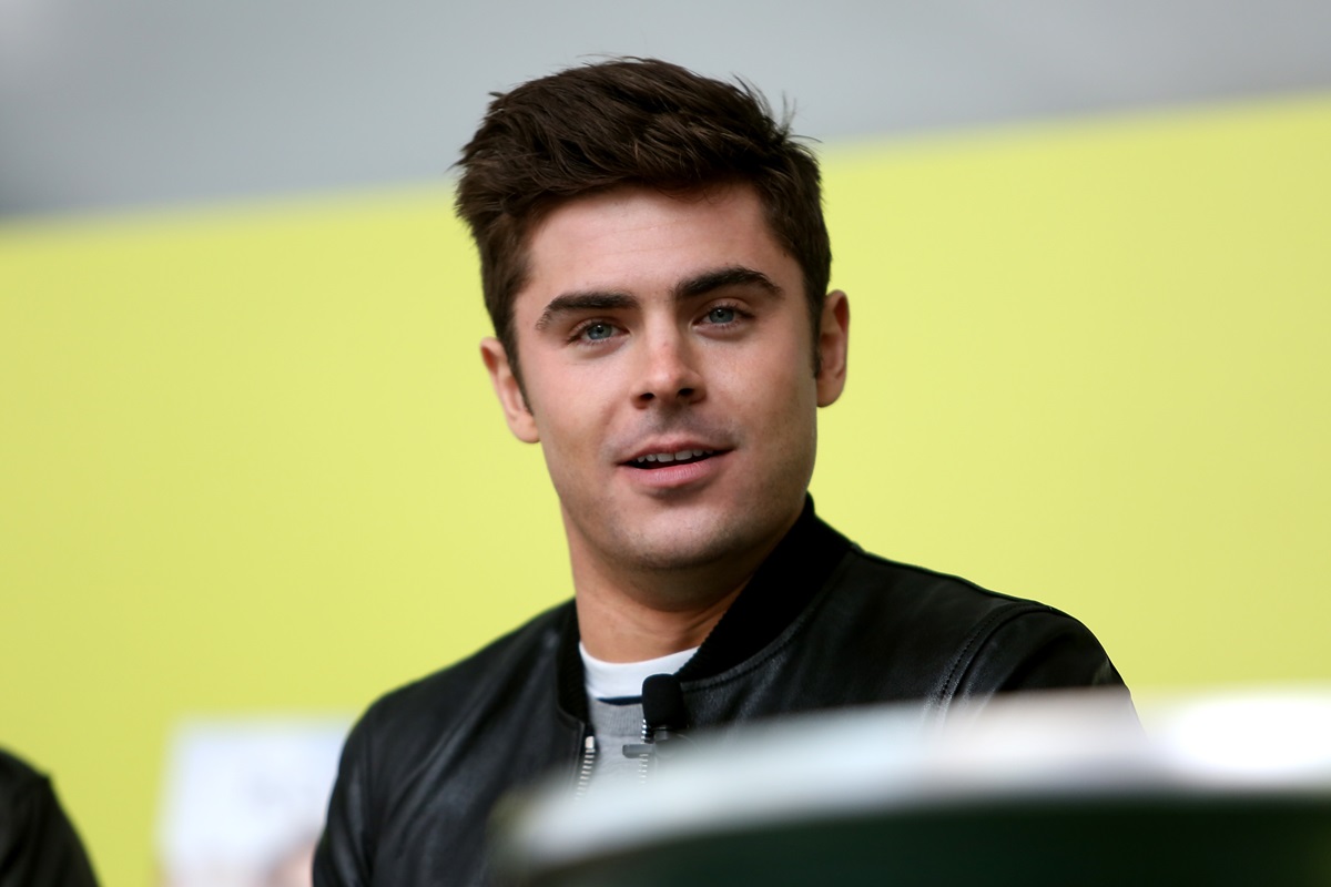 Zac Efron posing in a grey suit for the premiere of 'Neighbors'.