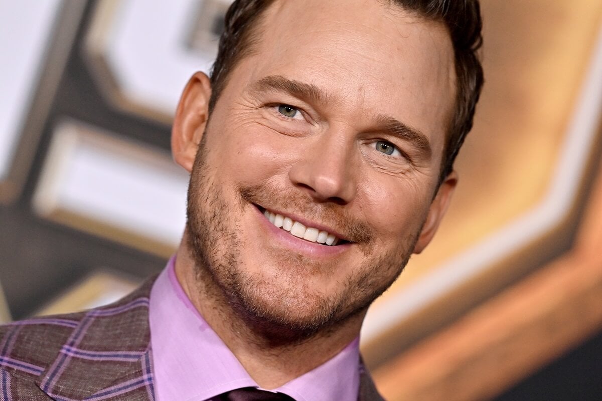 Chris Pratt smiling in a suit at the premiere of 'Guardians of the Galaxy Vol. 3'.