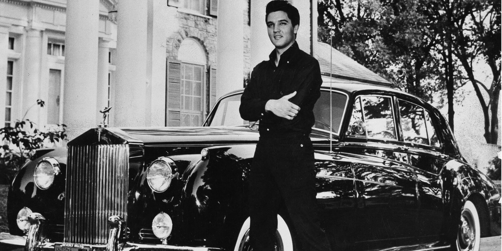 Elvis Presley poses in front of his Graceland home in Memphis, TN.