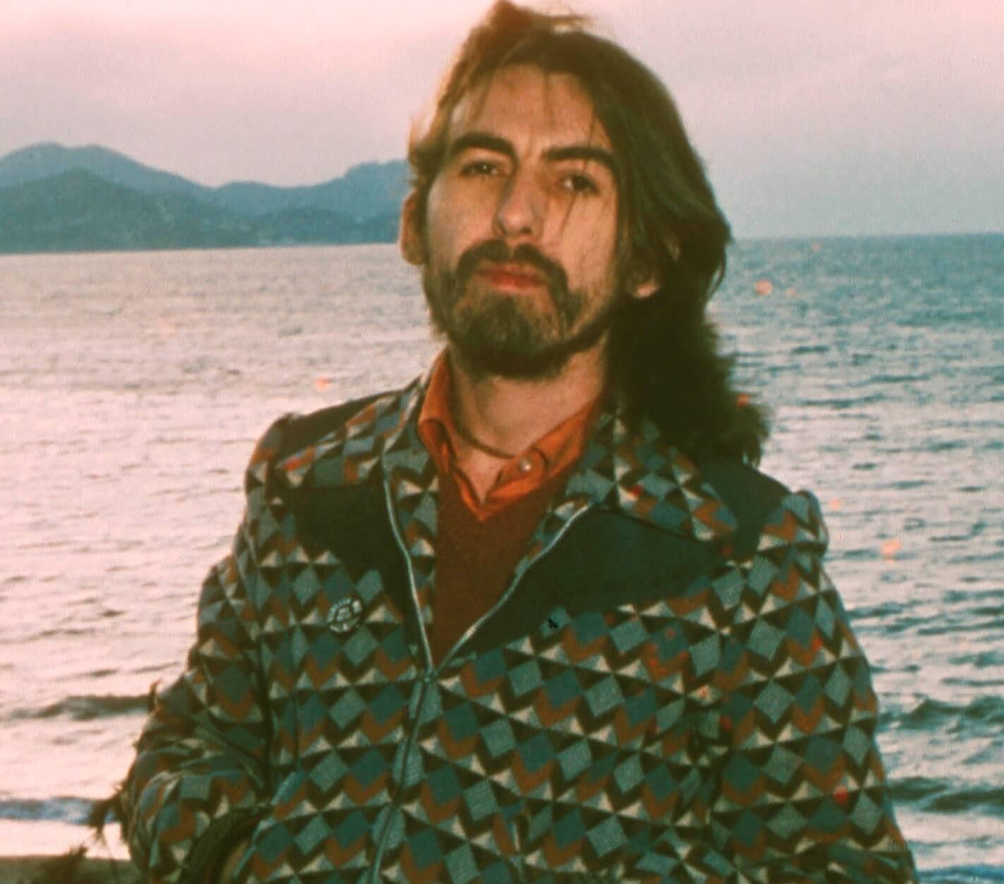 George Harrison standing in front of water
