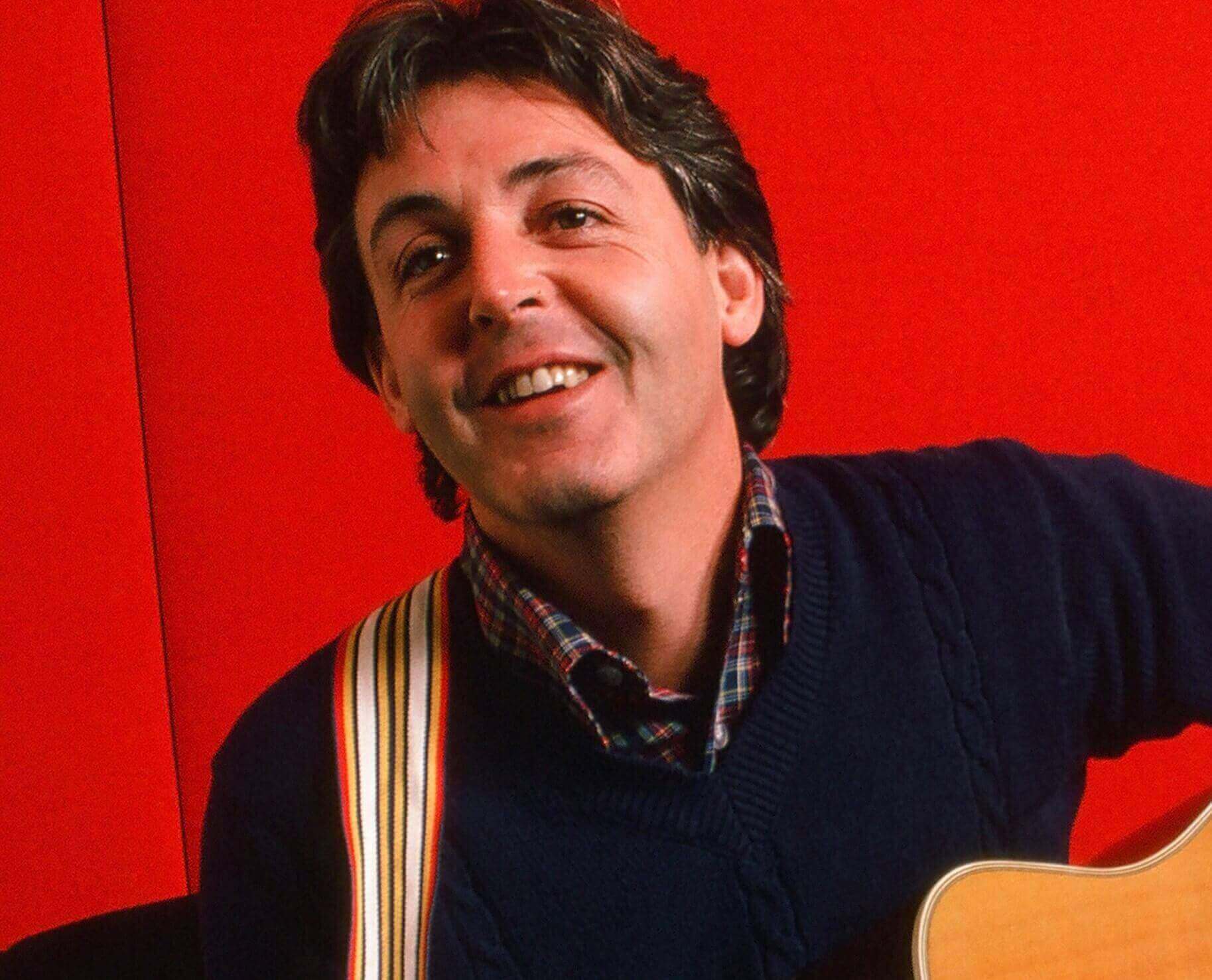 Paul McCartney with a red backdrop
