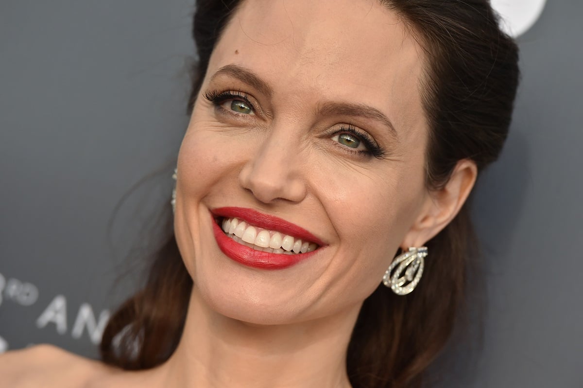 Angelina Jolie smiling at the 23rd Annual Critics' Choice Awards while wearing lipstick.