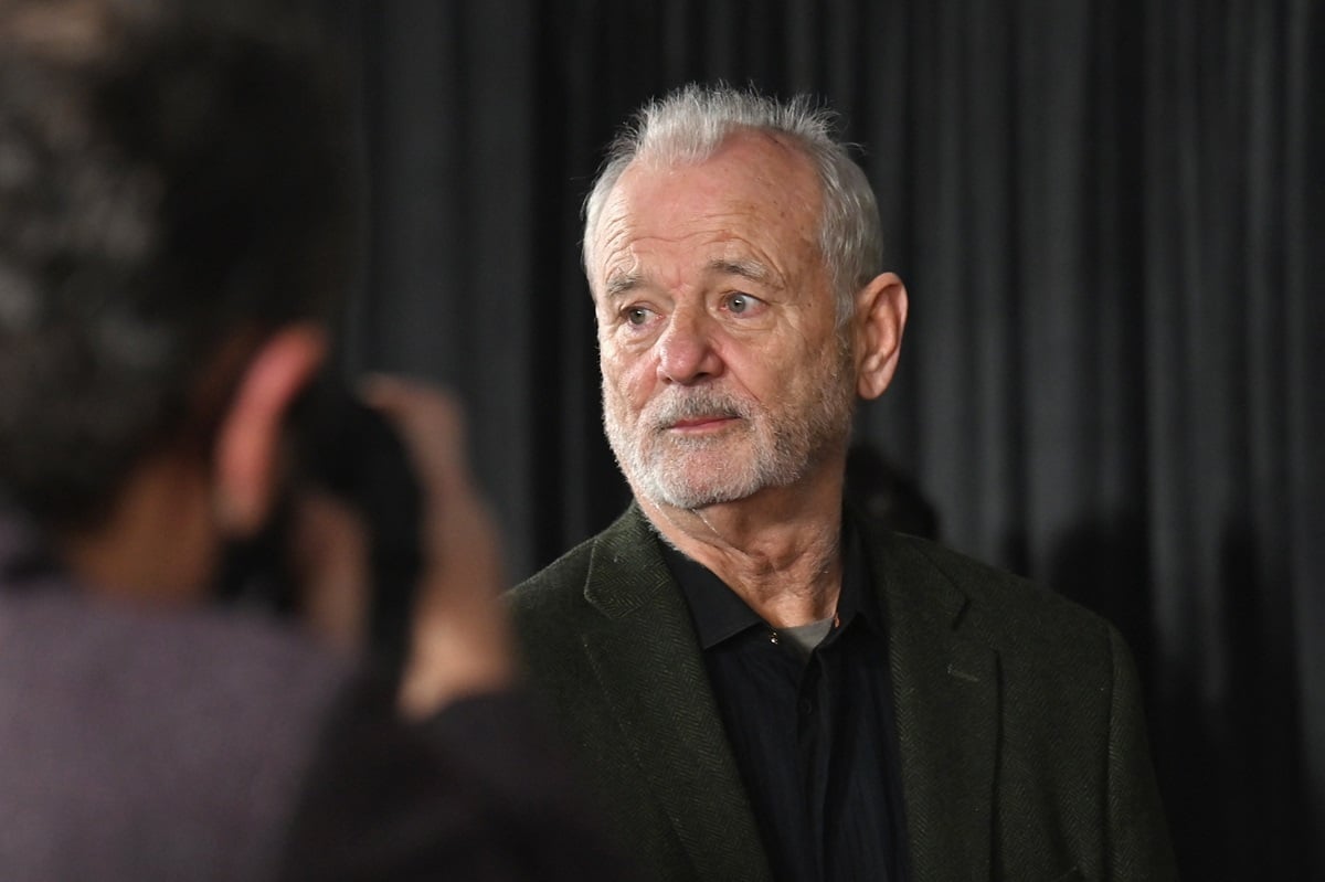 Bill Murray at the premiere of 'Ghostbusters:Afterlife', taking a picture in a black suit.