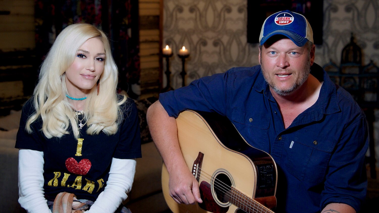 Gwen Stefani sitting next to Blake Shelton as Shelton holds an acoustic guitar