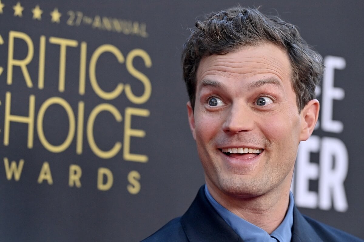 Jamie Dornan posing at the 27th annual critics choice awards while wearing a suit.