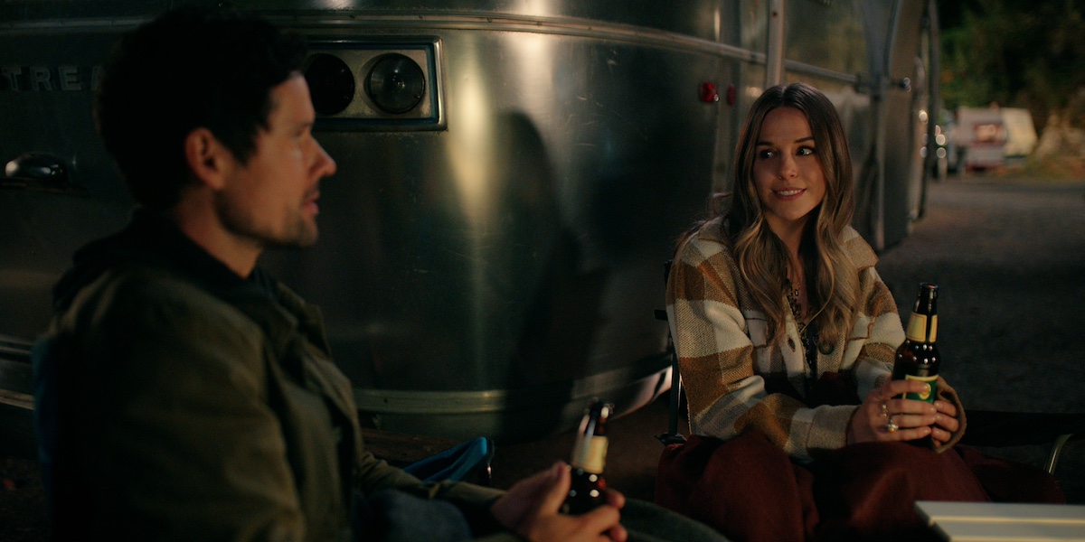Brady and Lark sitting outsider her camper drinking beer in 'Virgin River' Season 5