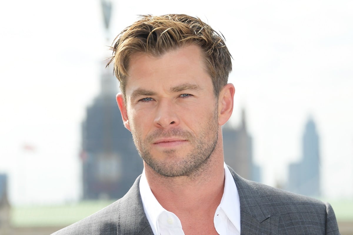 Chris Hemsworth posing at the 'Avengers: Endgame' photocall in a grey and white suit.