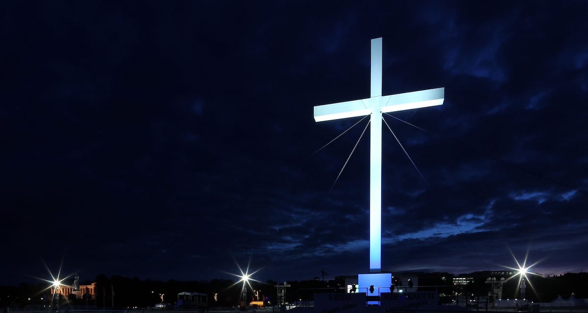 White Christian cross against the background of the night sky