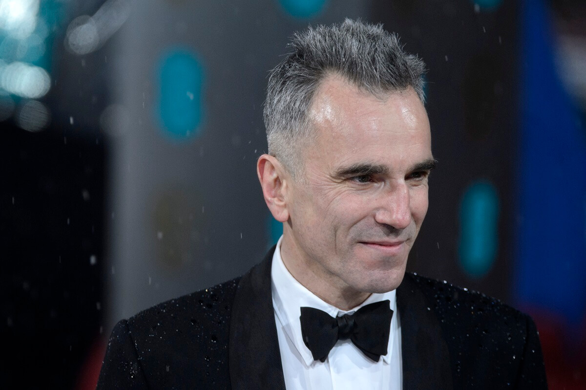 Daniel Day-Lewis posing at the the EE British Academy Film Awards while wearing a suit.