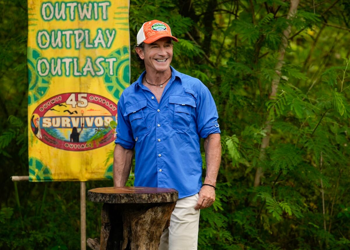 Jeff Probst in front of an "Outwit, Outplay, Outlast" banner in an episode of 'Survivor' Season 45