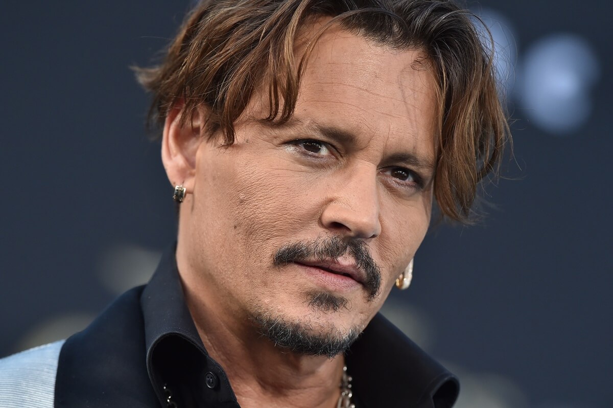Johnny Depp posing in a suit at the premiere of at the premiere of Disney's 'Pirates of the Caribbean: Dead Men Tell No Tales'.