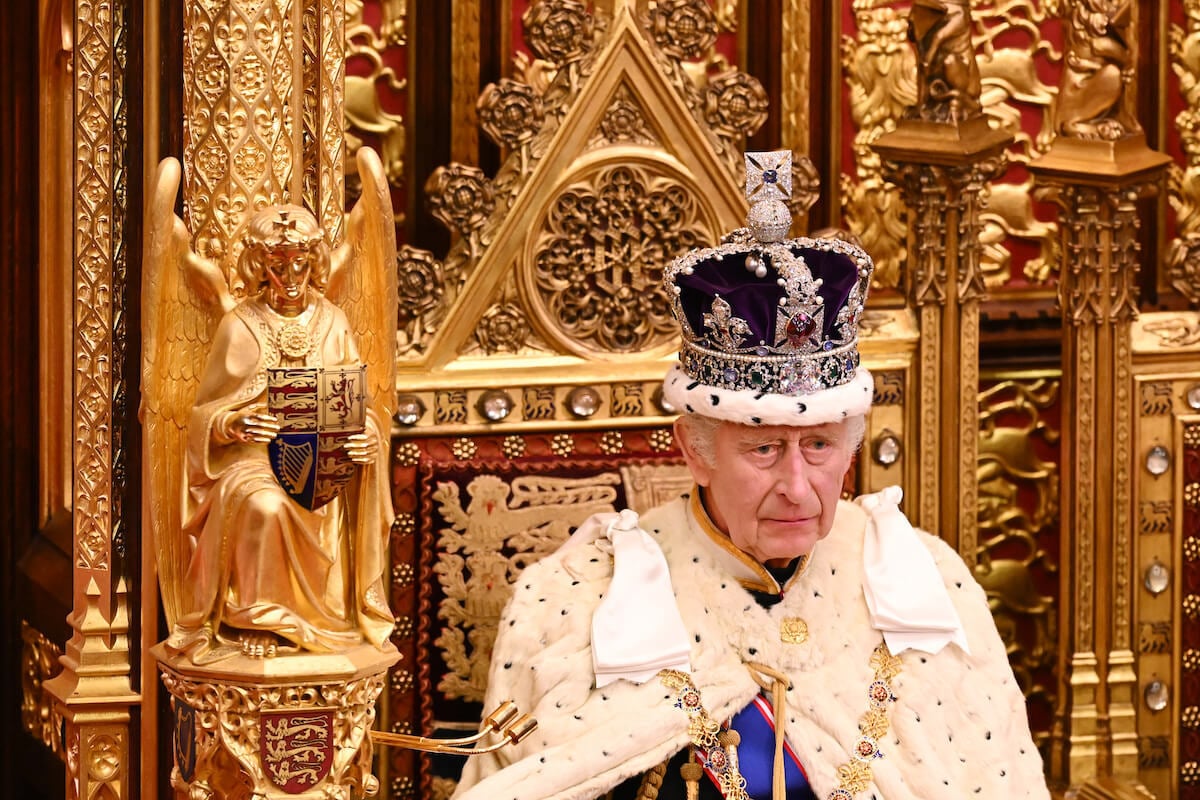 King Charles III looks on at the state opening of parliament wearing a crown.