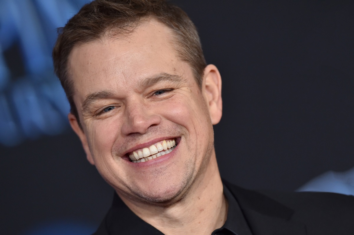 Matt Damon smiling at the premiere of 'Marry Poppins Returns' while wearing a black suit.