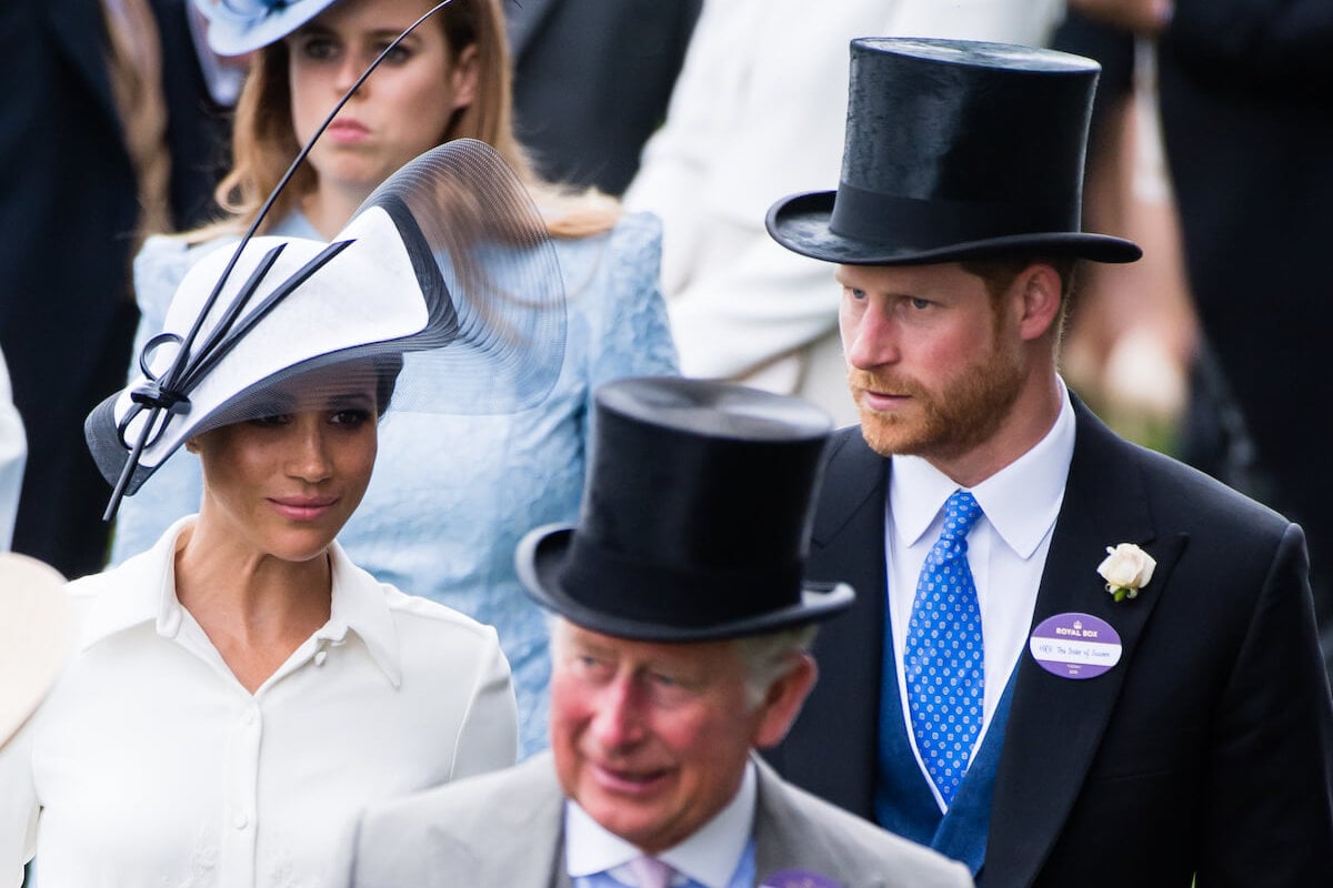 Meghan Markle and Prince Harry, who are reportedly banned from being discussed at King Charles III's 75th birthday party, walk behind the monarch