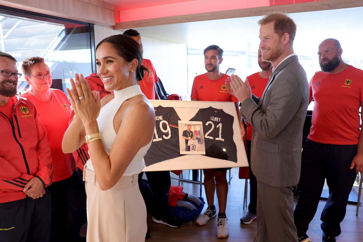 Meghan Markle and Prince Harry, whose children Prince Archie and Princess Lilibet may have to deal with consequences of 'Endgame' book, clap