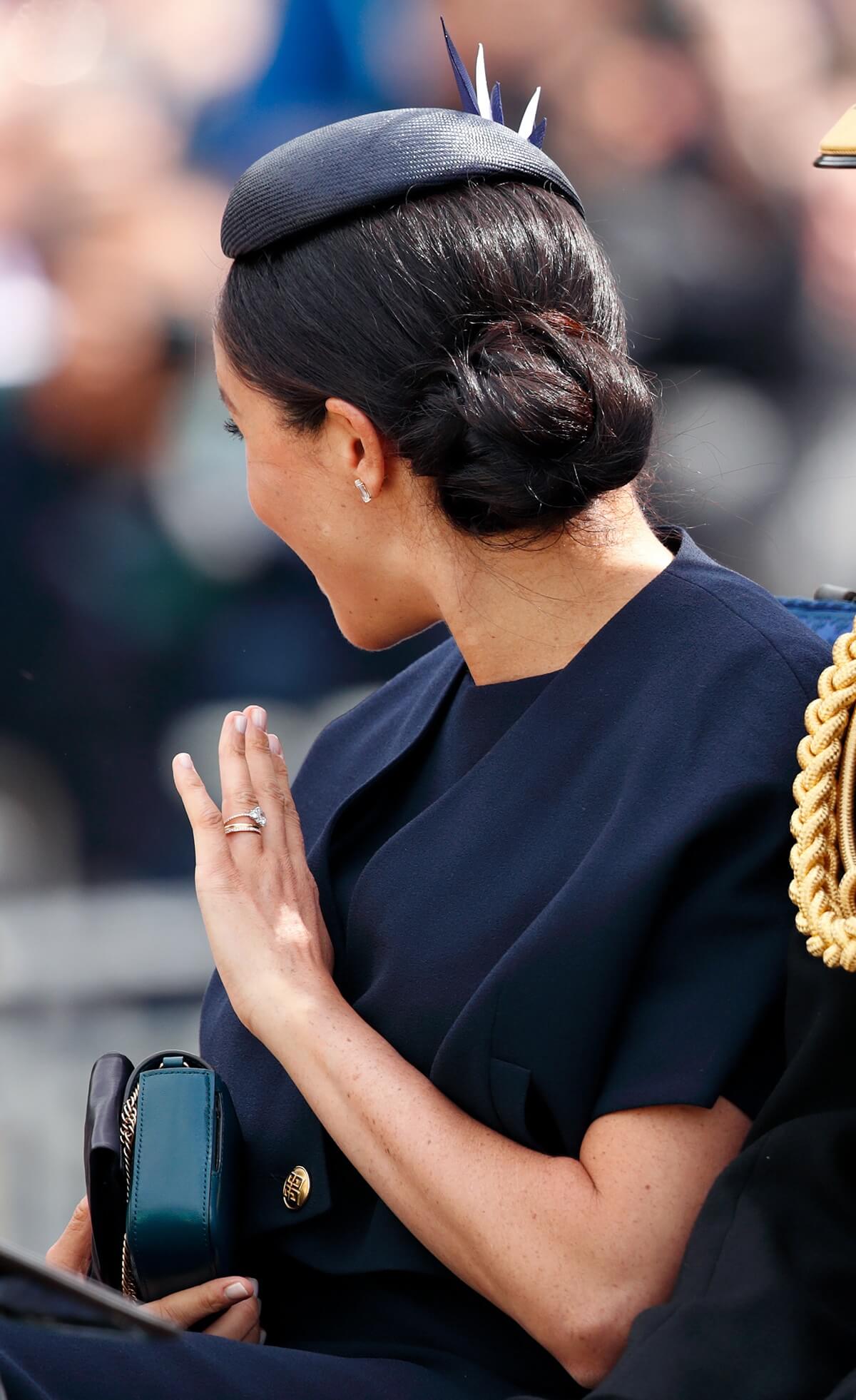Meghan Markle waves as she travels down The Mall in a horse drawn carriage during Trooping The Colour 2018
