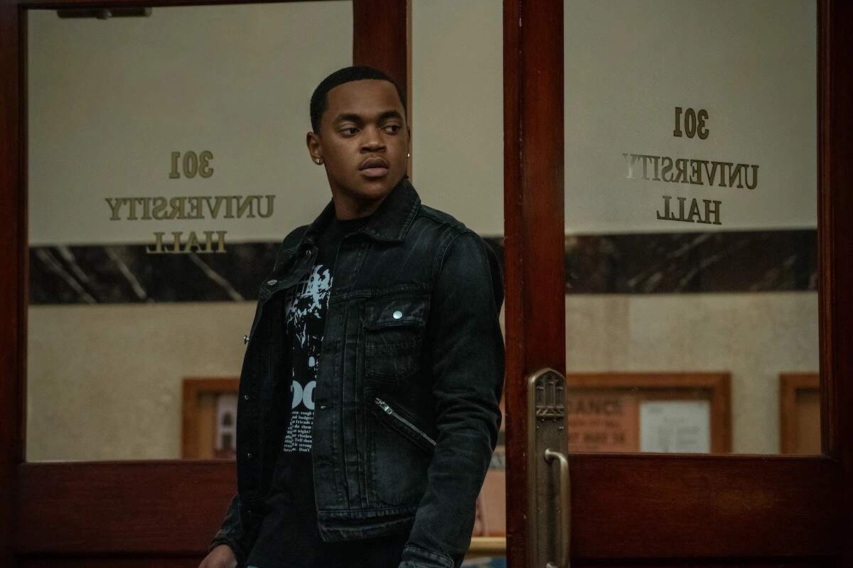 Michael Rainey Jr. wearing a leather coat and standing in an office while filming Power