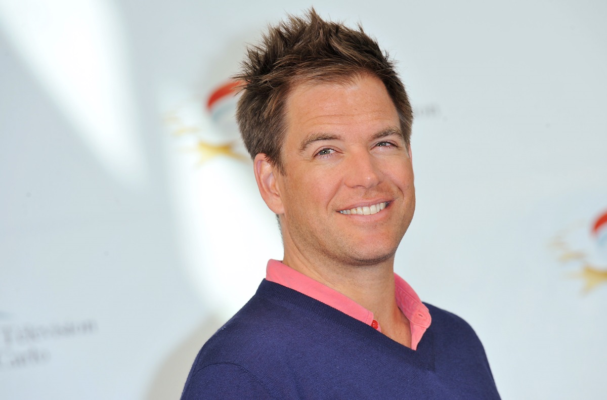 Michael Weatherly posing in a blue shirt with a pink collar during a photocall for "NCIS" tv series.