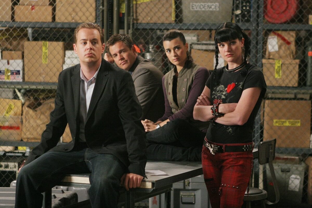Four 'NCIS' cast members standing in front of evidence cages