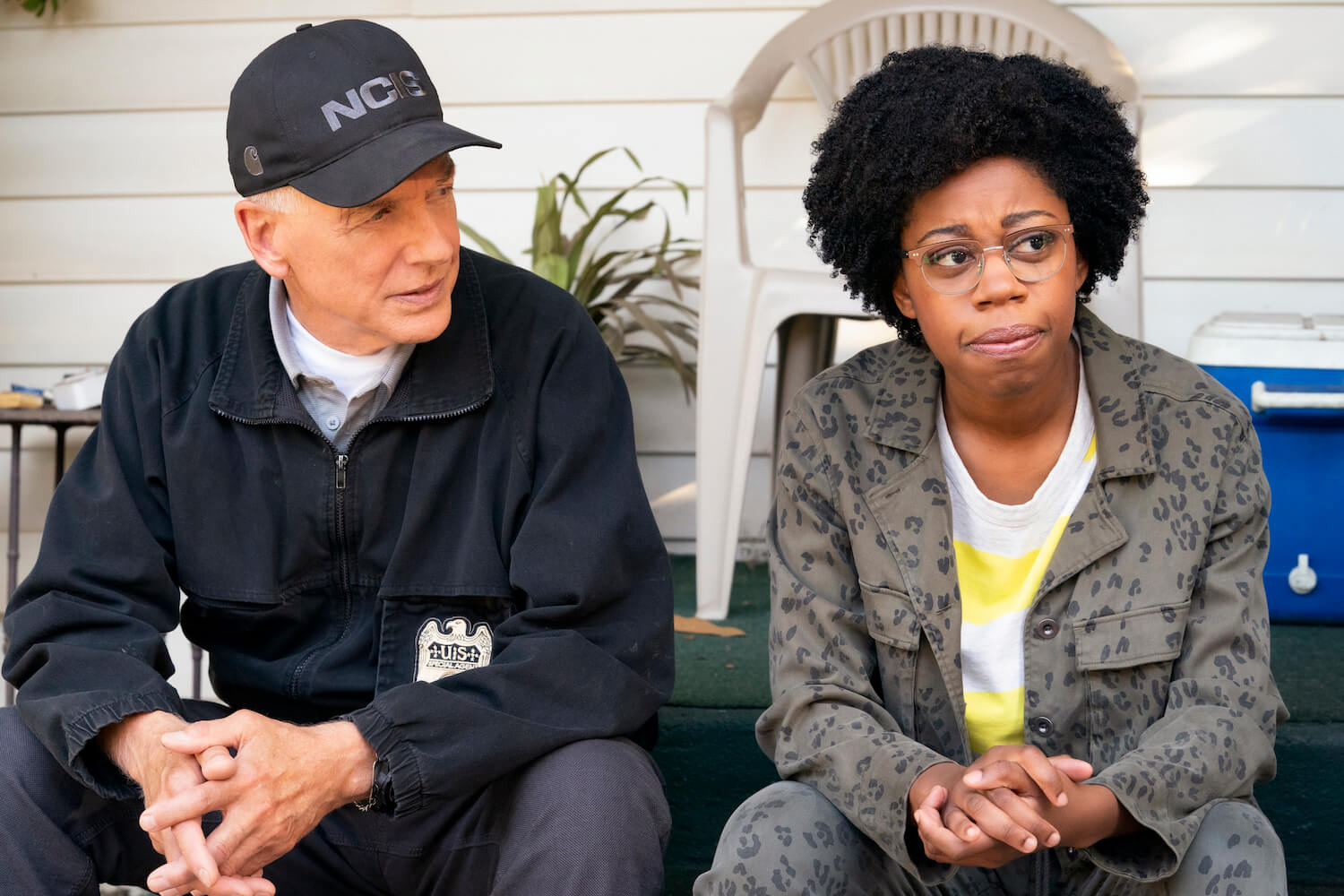 'NCIS' star Mark Harmon in uniform sitting next to Diona Reasonover in a scene in the show