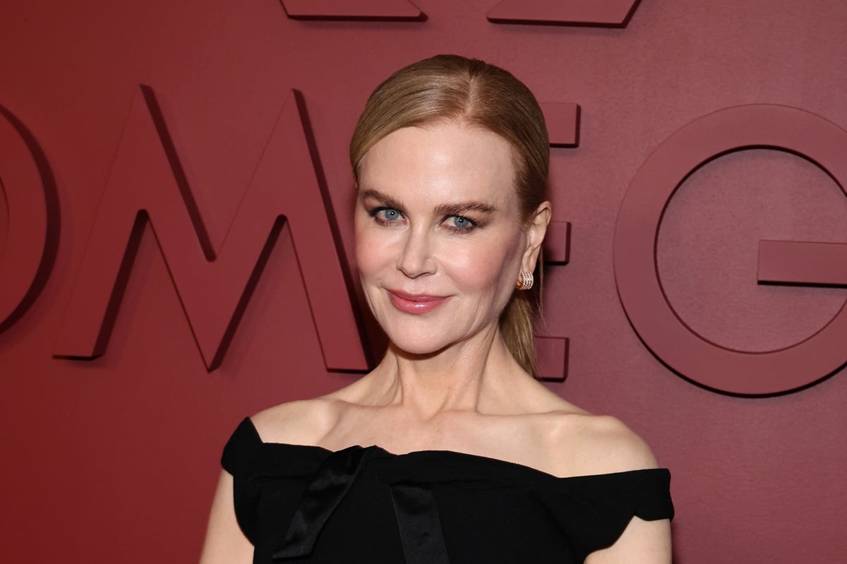 Nicole Kidman smirking in a black dress at the opening party for the Planet Omega Exhibition