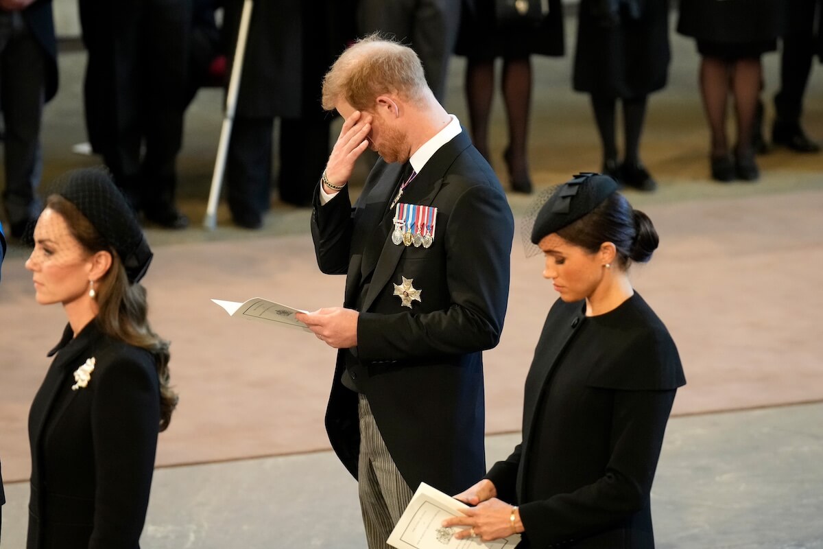 Prince Harry appears to wipe tears while paying his respects to Queen Elizabeth at her funeral in 2022