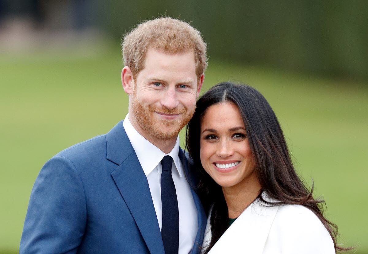 Prince Harry and Meghan Markle, who a body language expert says appear as a 'separte couple' now, attend an official photocall to announce their engagement at The Sunken Gardens, Kensington Palace