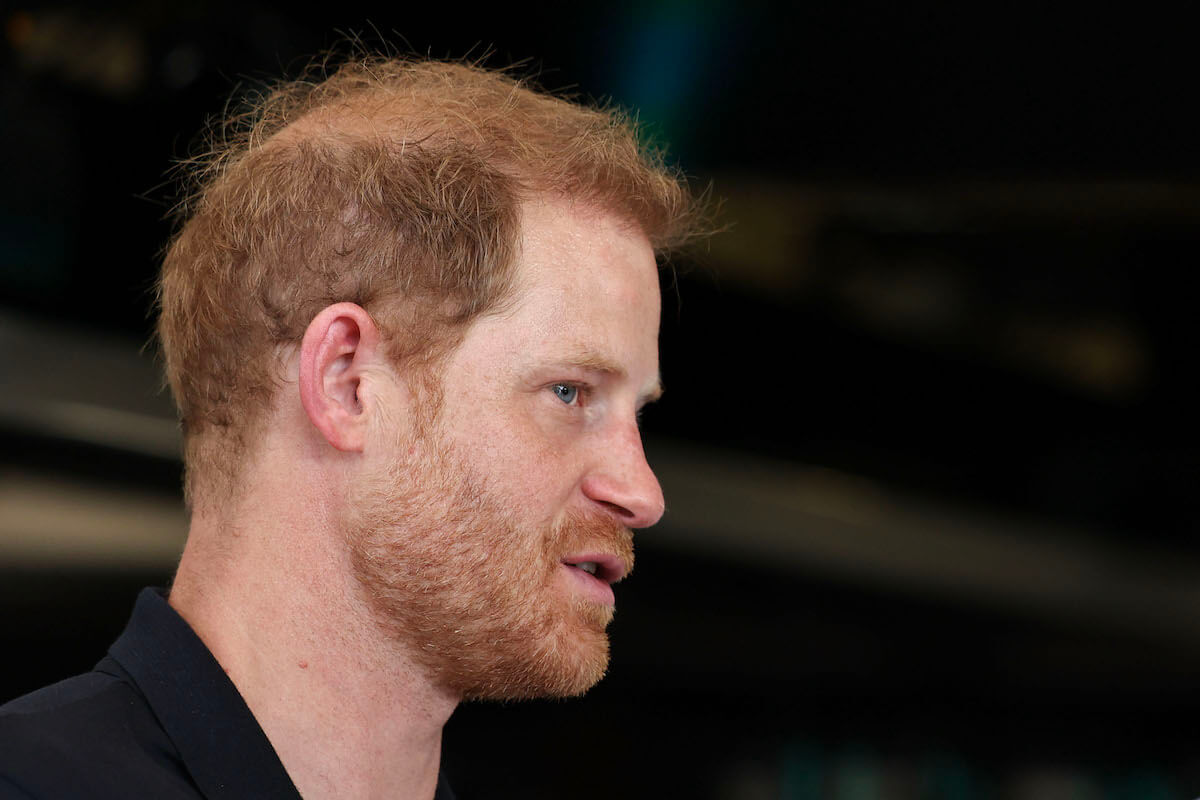 Prince Harry, who the royal family's 'continued punishment' of hurts them, per Omid Scobie, looks on