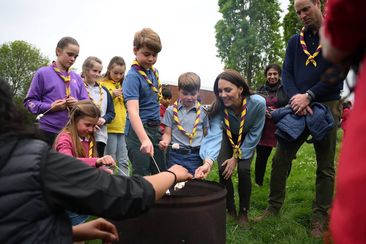 Prince William and Kate Middleton, who avoid Princess Diana's 'biggest parenting regret' with their own children, stand with Princess Charlotte, Prince George, and Prince Louis around a bonfire toasting marshmallows. 