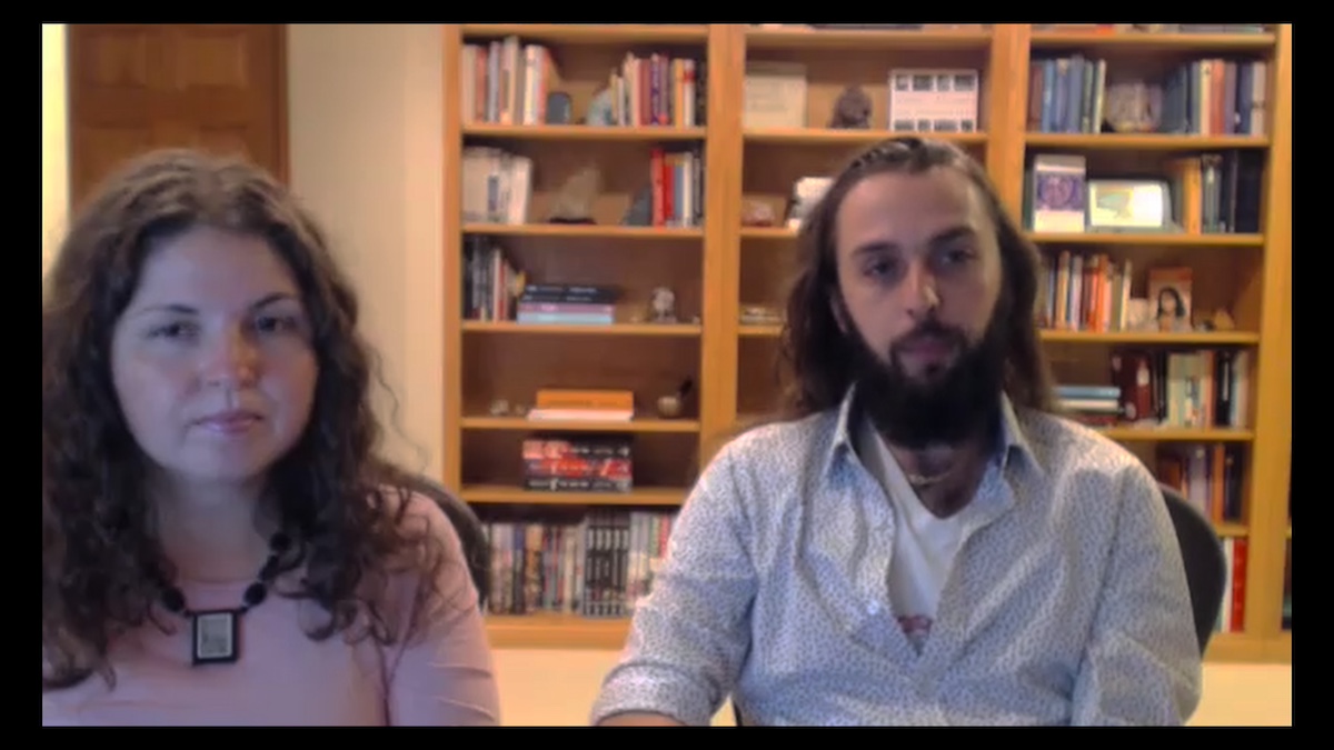 Sheleia and Jeff Ayan sitting in front of a bookshelf in Prime Video's 'Desperately Seeking Soulmate: Escaping Twin Flames Universe'