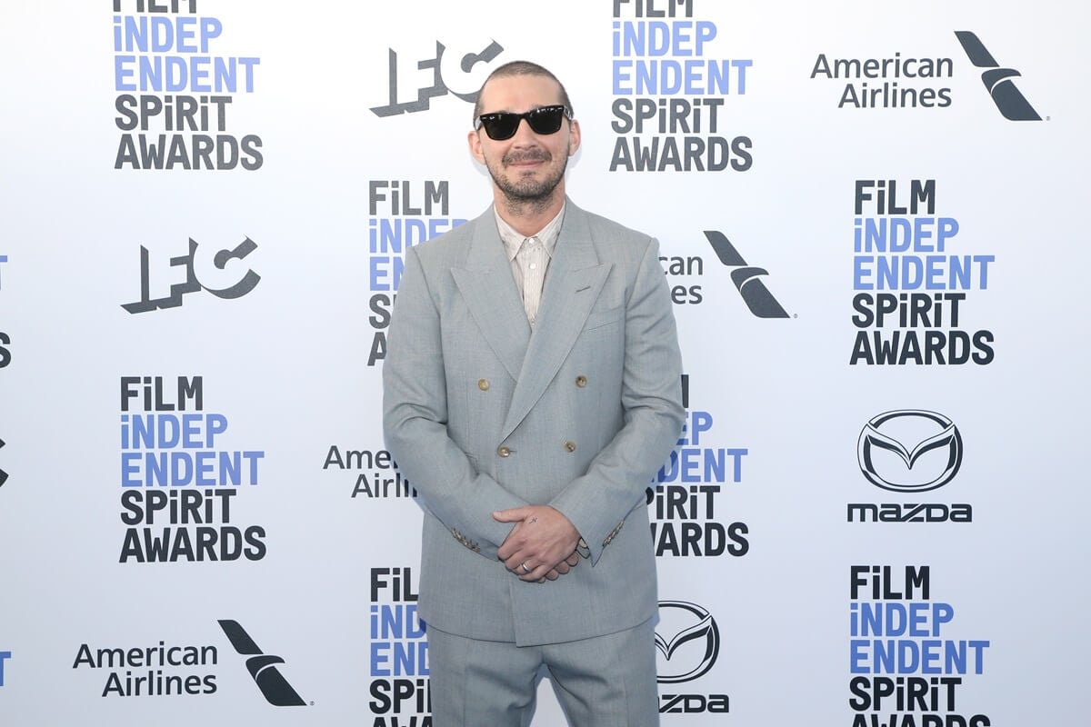 Shia LaBeouf posing in a grey suit at the Independent Spirit Awards.