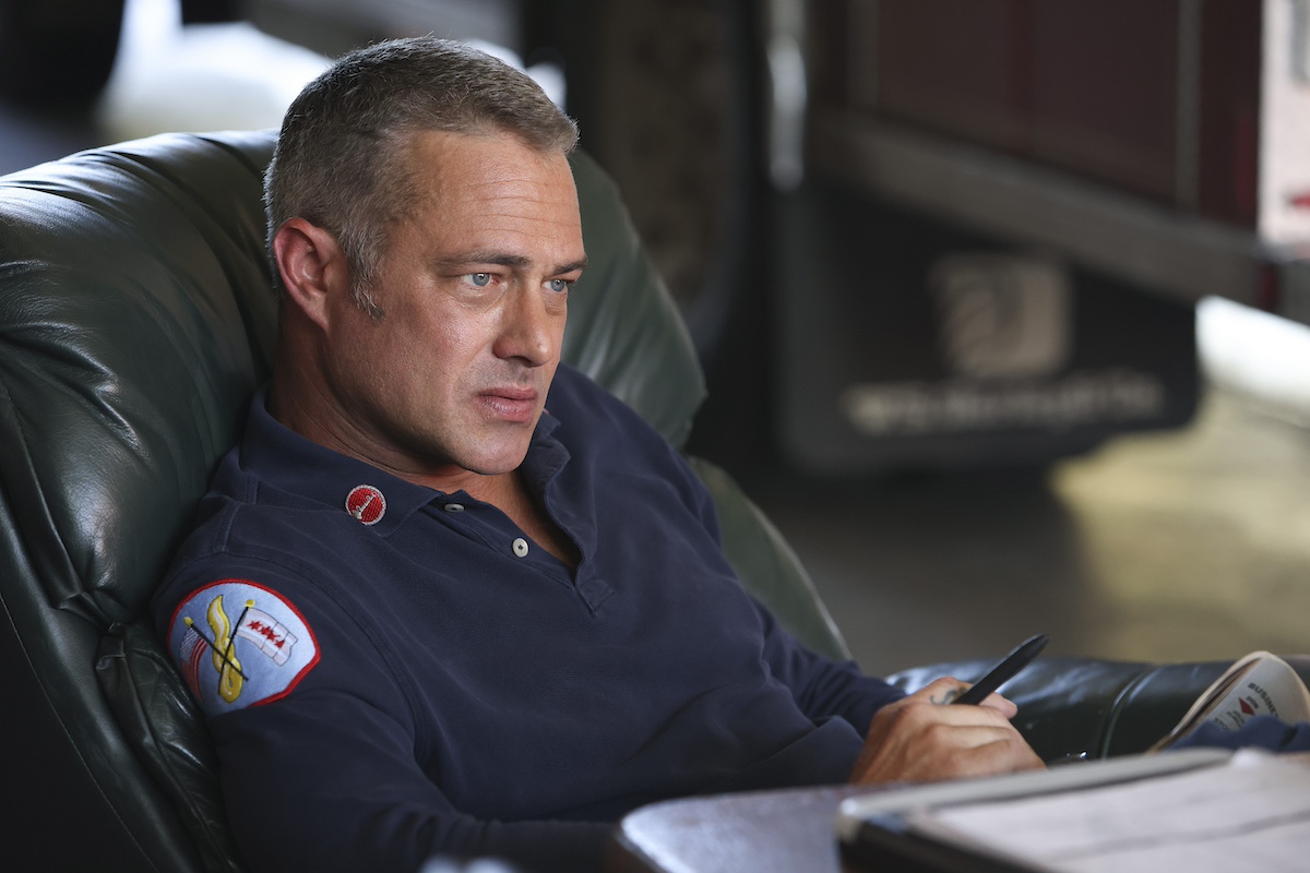 Taylor Kinney as Kelly Severide sitting at a desk in 'Chicago Fire' Season 11
