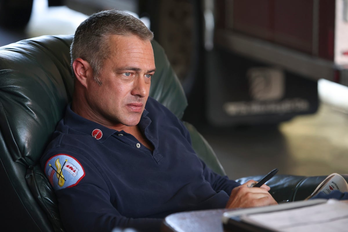 Taylor Kinney as Kelly Severide sitting at a desk in 'Chicago Fire' Season 11