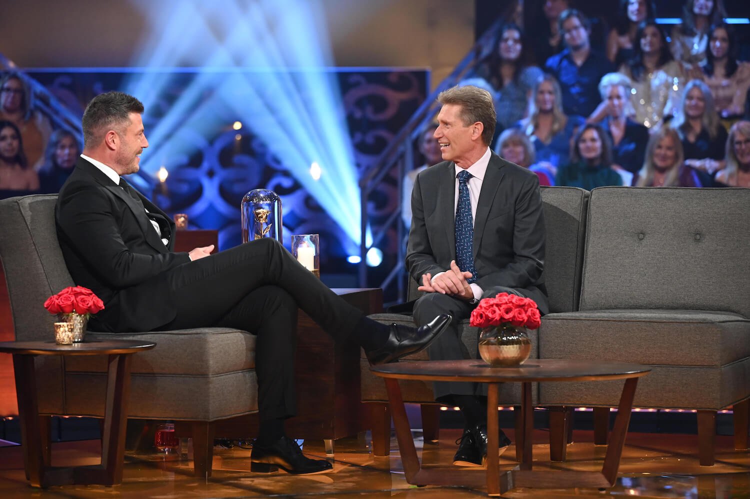 Jesse Palmer sitting across from Gerry Turner on stage during 'The Golden Bachelor' Women Tell All 