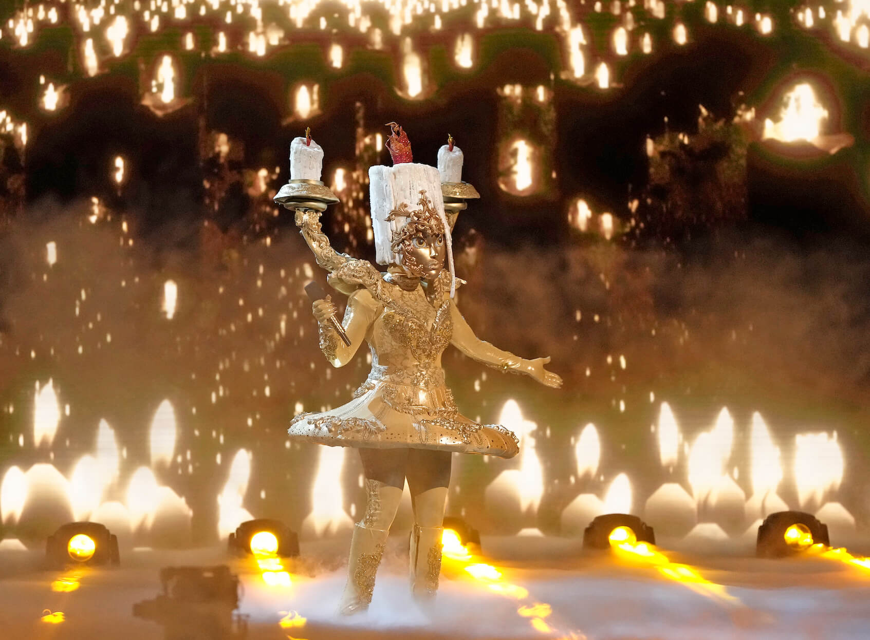 'The Masked Singer' Season 10 mask Candelabra singing on stage surrounded by candle imagery
