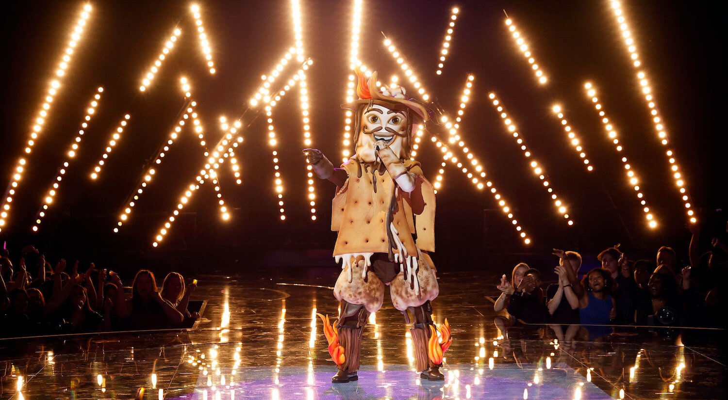 S'more singing on stage in front of yellow lights on 'The Masked Singer' Season 10 Disco Night