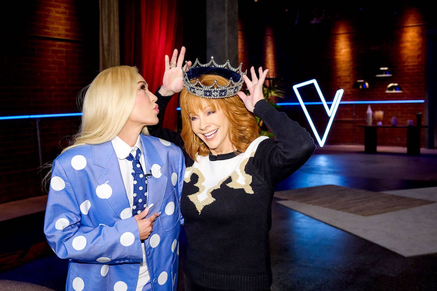 'The Voice' star Gwen Stefani kissing Reba McEntire's cheek as McEntire holds a crown over her head.