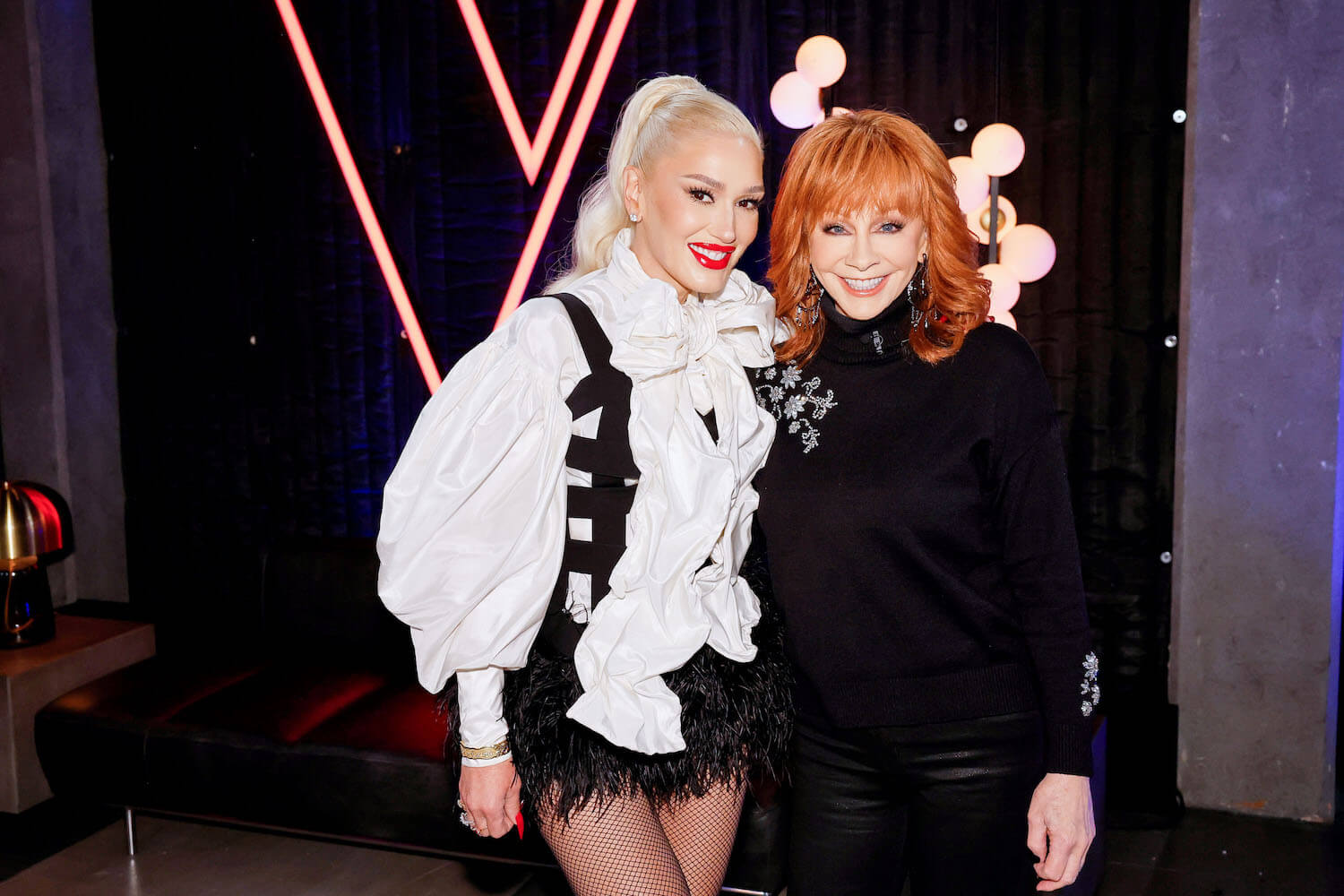 'The Voice' Season 24 stars Gwen Stefani and Reba McEntire smiling with their arms around each other