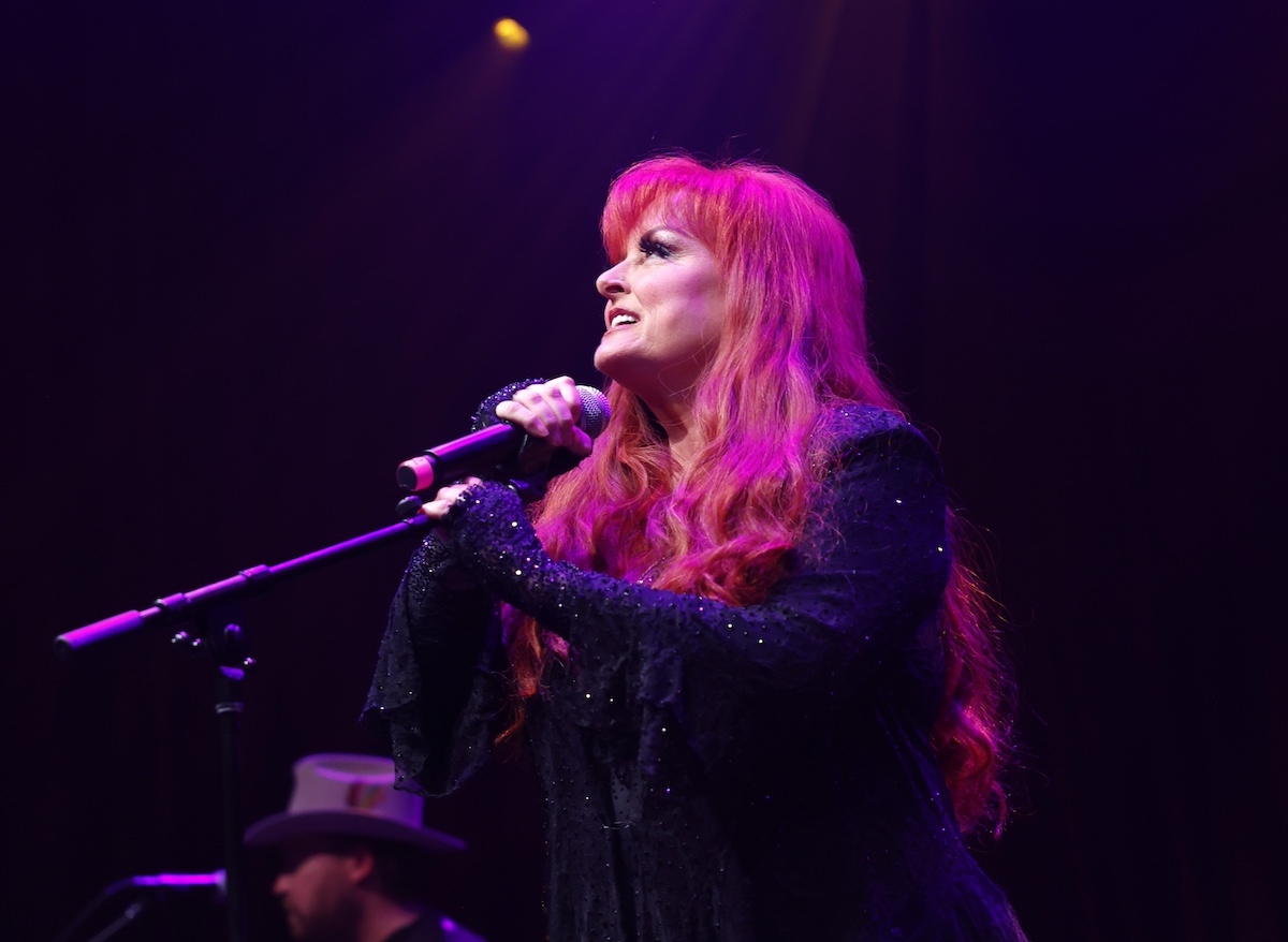 'The Voice' mentor Wynonna Judd holding a microphone and singing at Brooklyn Bowl Nashville in 2023