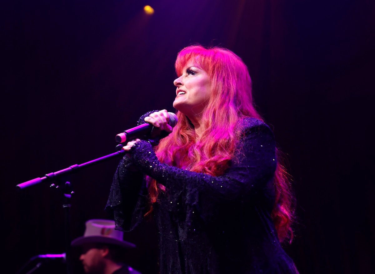 'The Voice' mentor Wynonna Judd holding a microphone and singing at Brooklyn Bowl Nashville in 2023