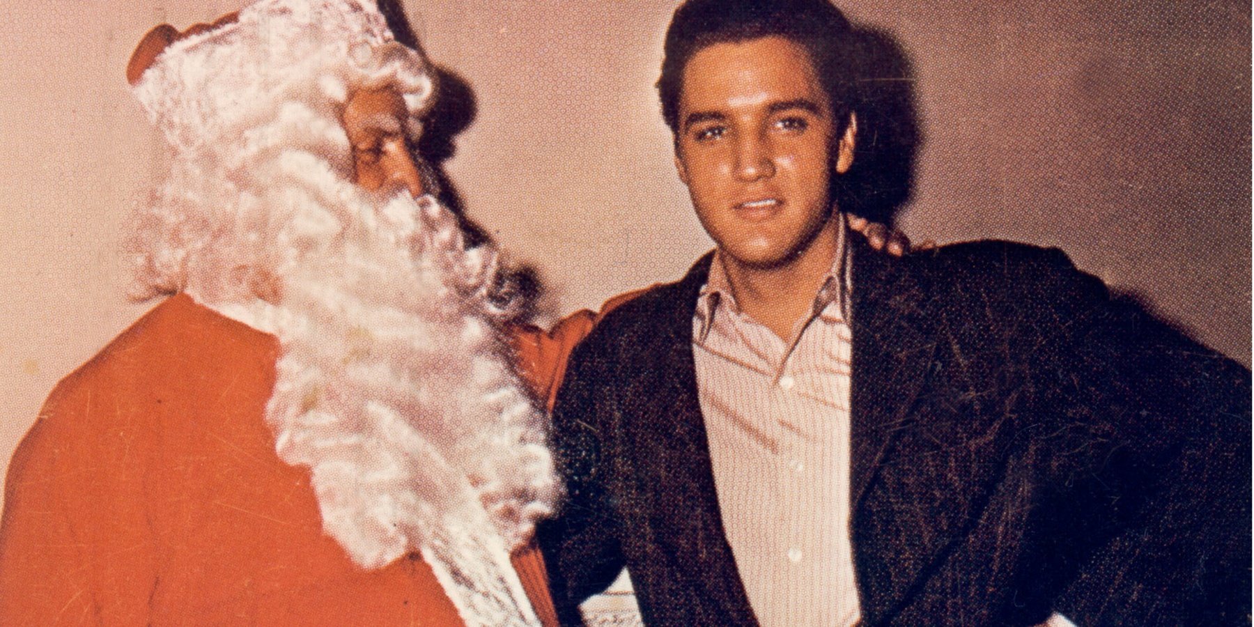 Elvis Presley poses with Colonel Tom Parker, dresses as Santa Claus, during Christmas.