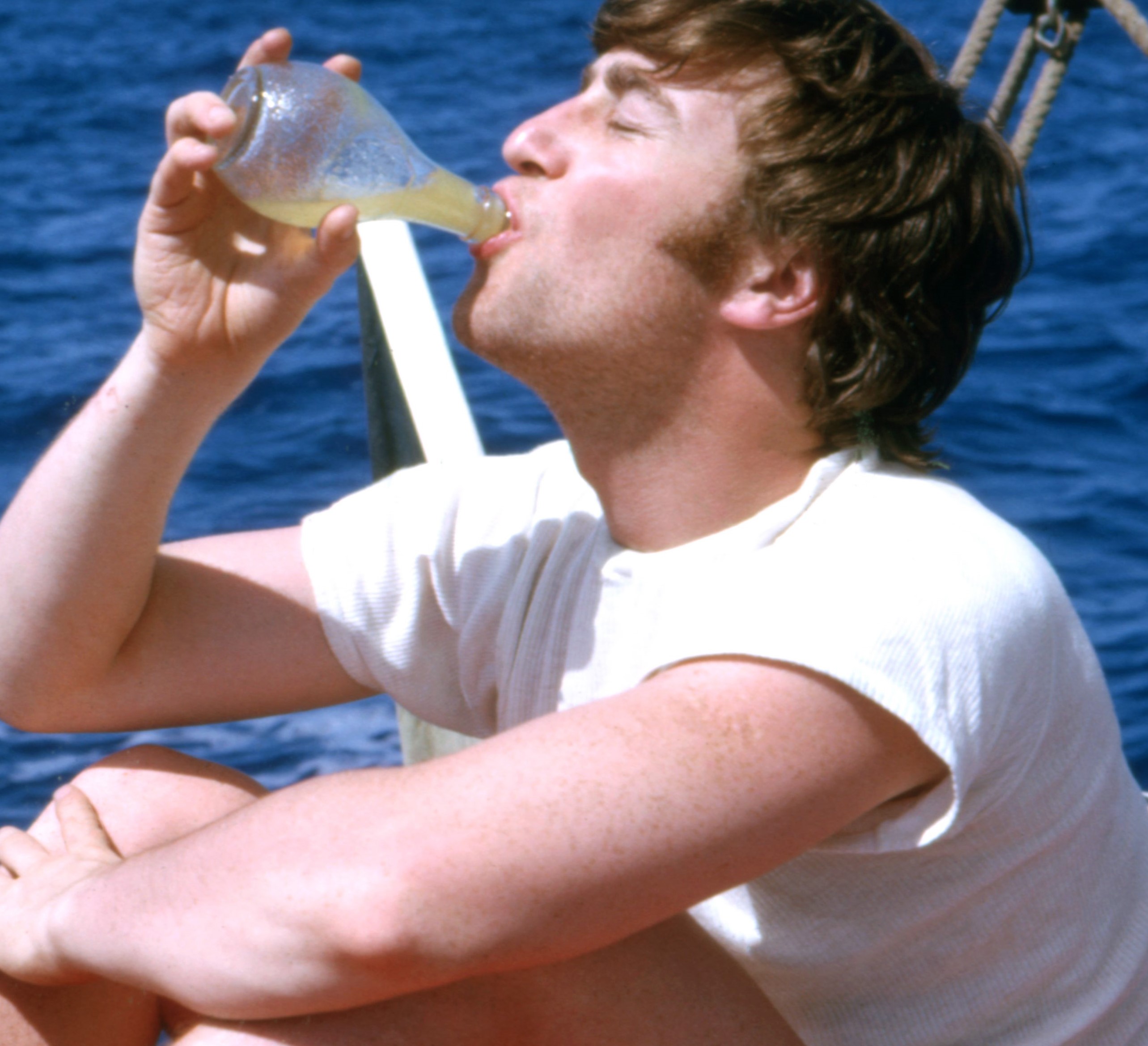 John Lennon drinking something