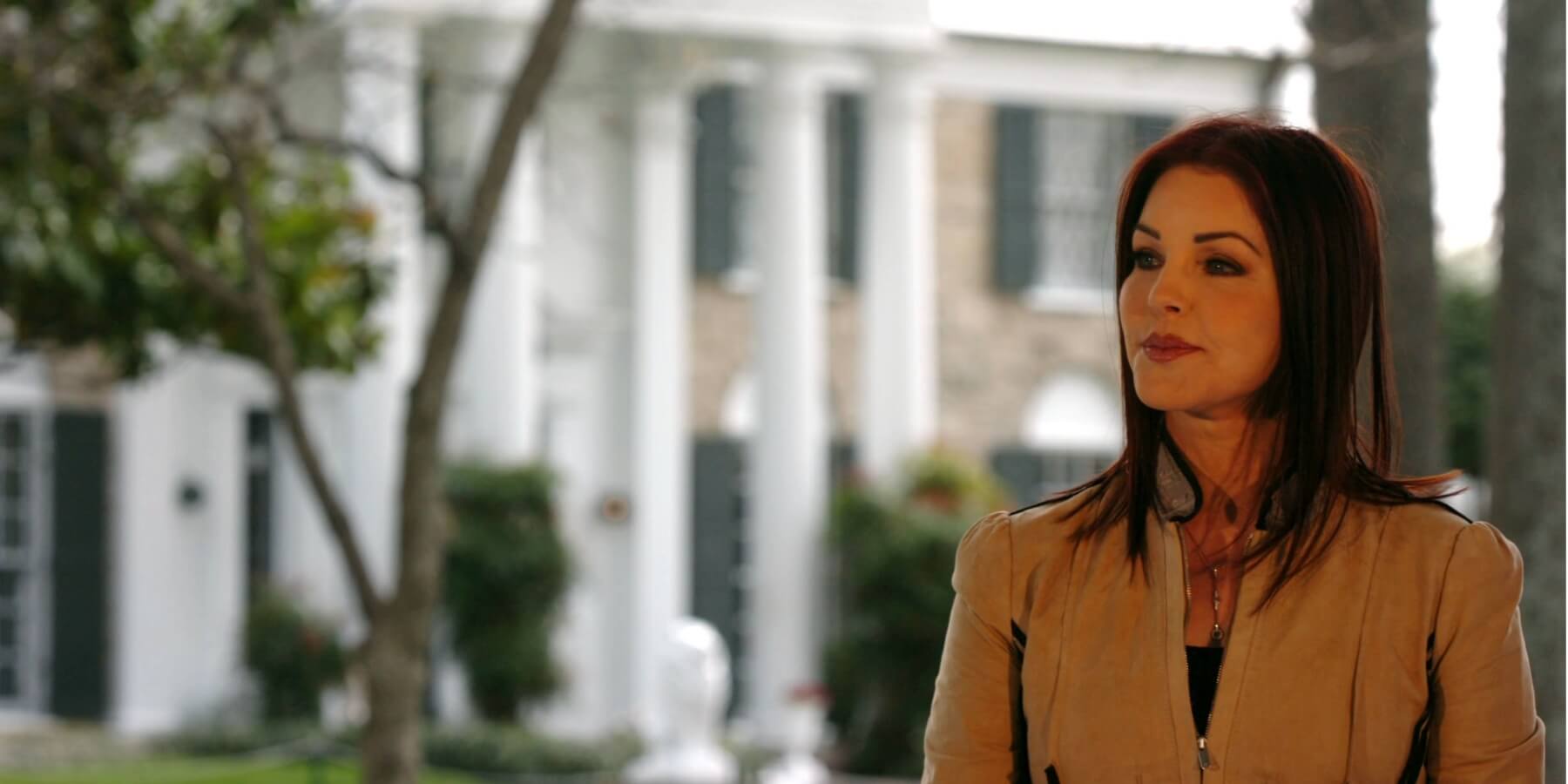 Priscilla Presley poses outside of Elvis Presley's Graceland home in 2006.