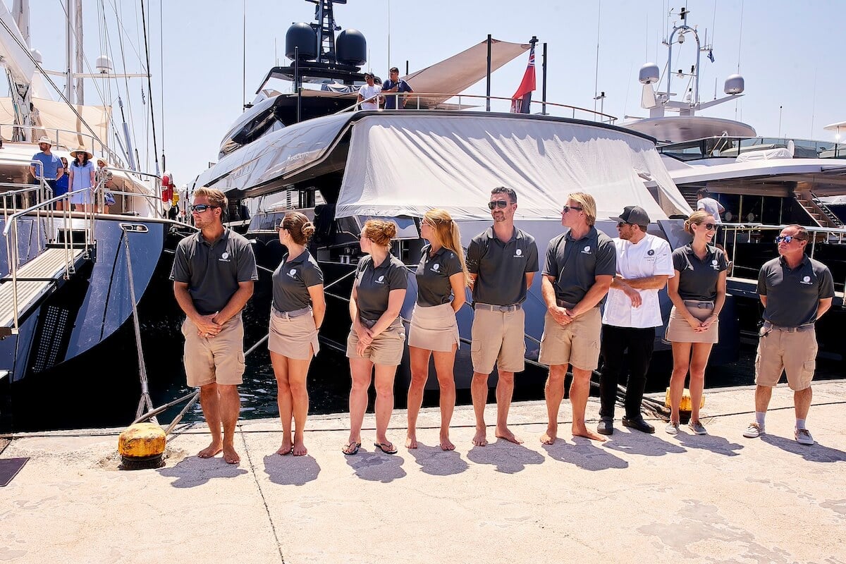 Crew of 'Below Deck Sailing Yacht' standing in front of the ship
