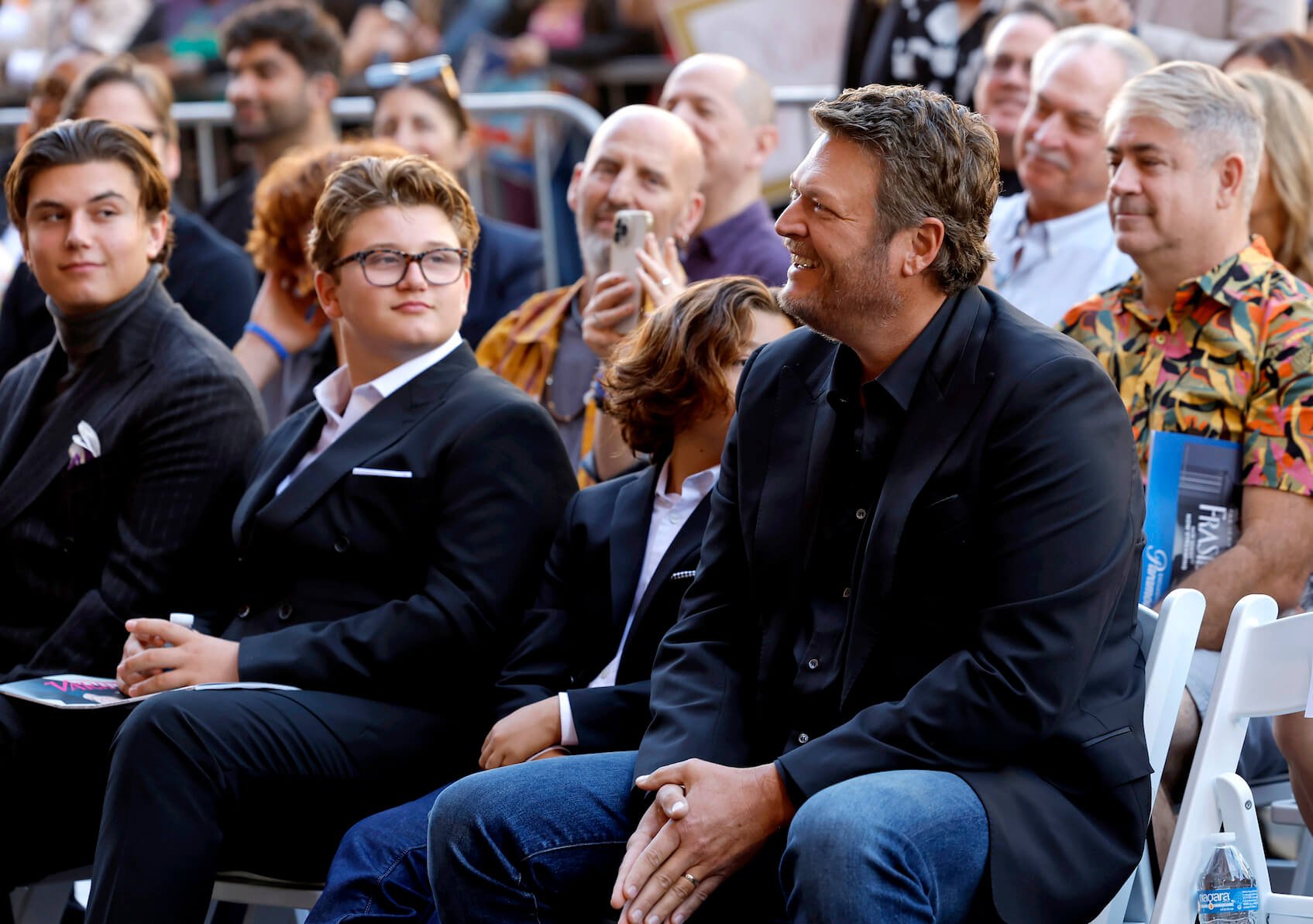 Blake Shelton laughing while sitting next to Gwen Stefani's kids