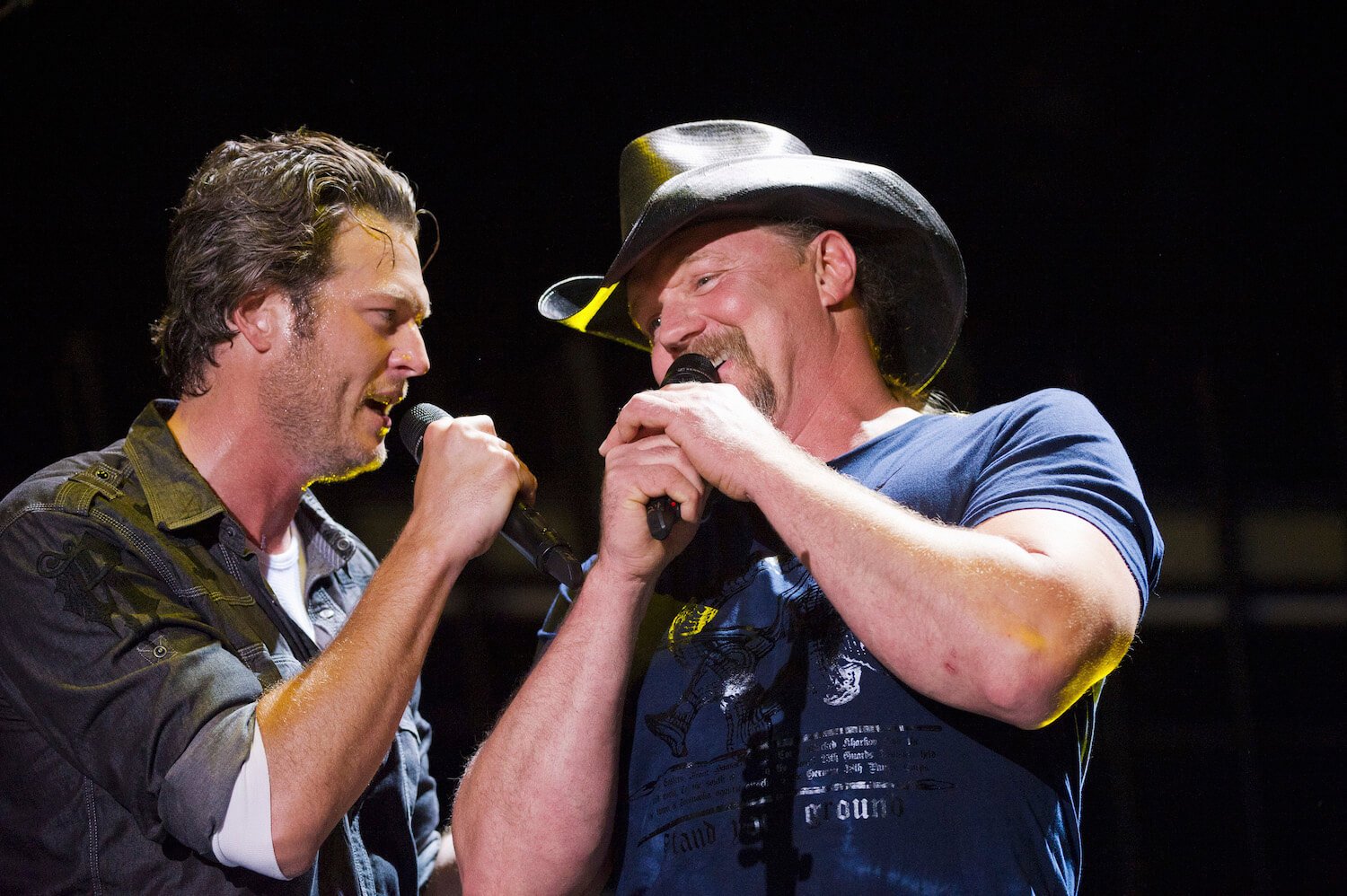 Country singers Blake Shelton and Trace Adkins sweating and singing next to each other on stage