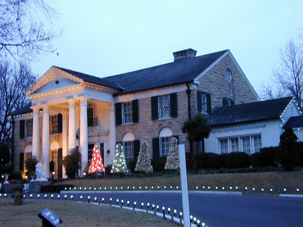 Elvis Presley's home of Graceland with Christmas trees on front lawn